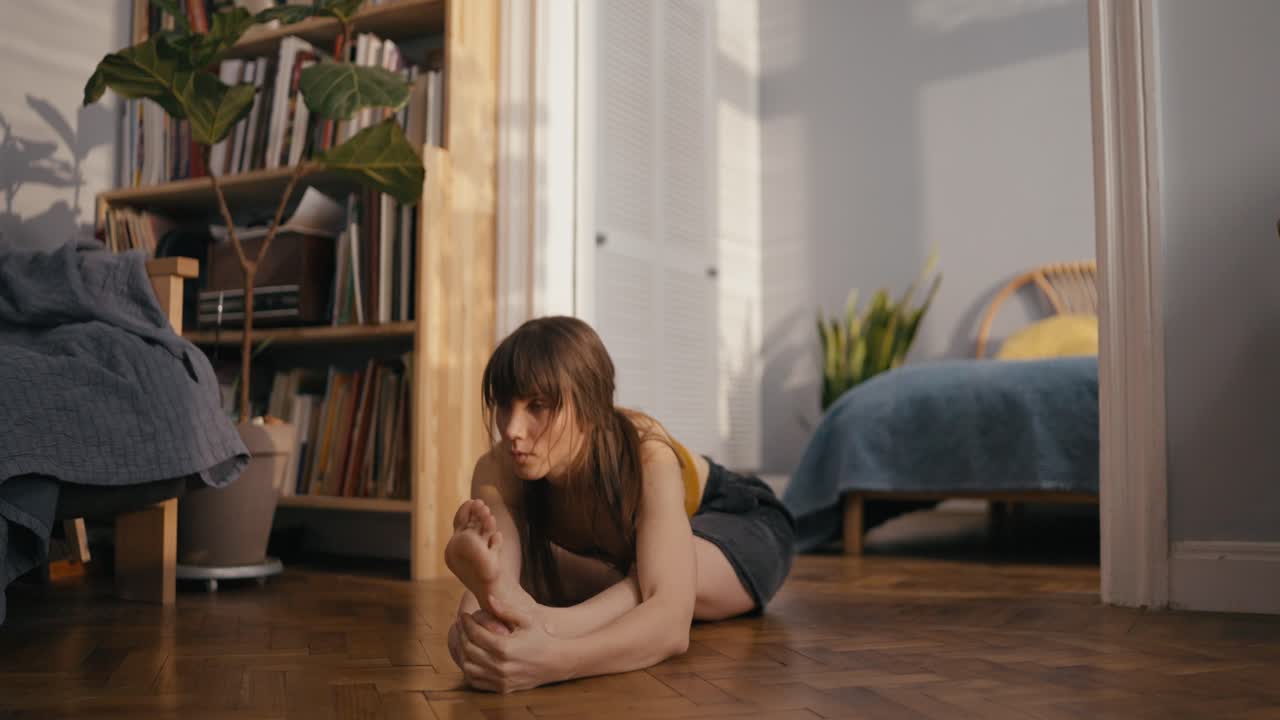 Donna che fa stretching yoga sul pavimento