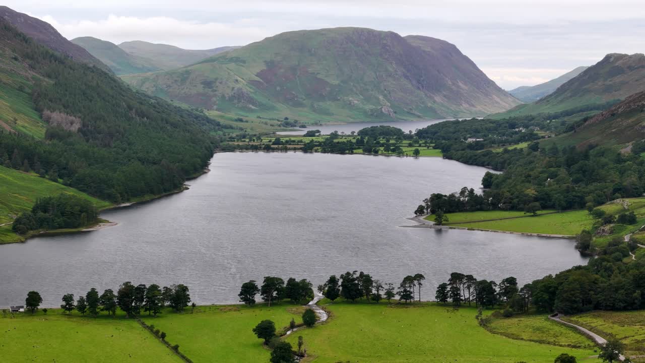 Aerial drone shot of Buttermere in the Lake District on a moody, overcast day with mountains, forest and lake