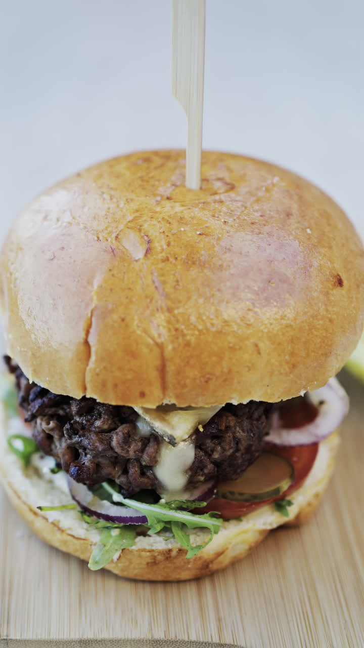 Close up of a hamburger on a plate at a restaurant. Vertical
