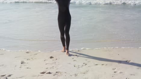 male surfer carrying surfboard on his head at beach 4k