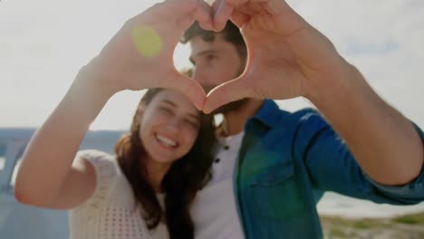 animation of red shapes over caucasian couple at beach