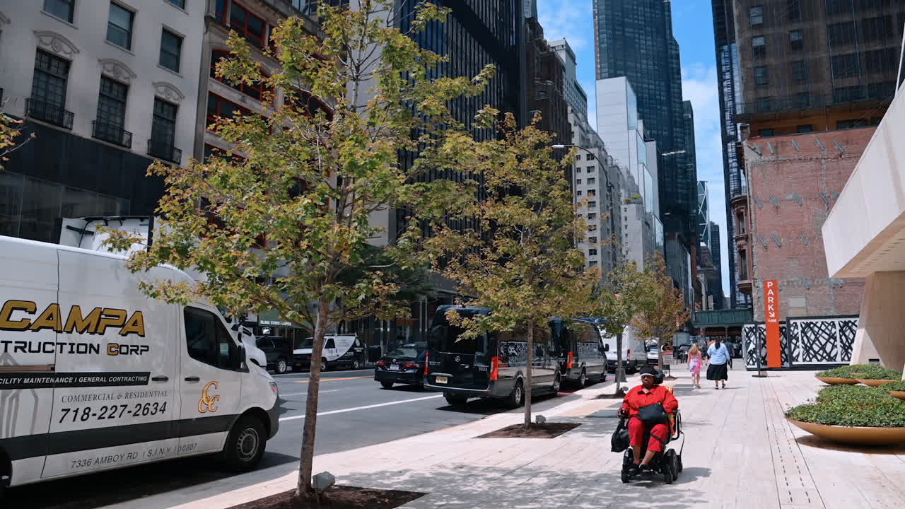 New York, USA, 4 August 2025: Modern buildings and traffic on New York City street. Street view in Manhattan with modern buildings, cars, and pedestrians in New York City