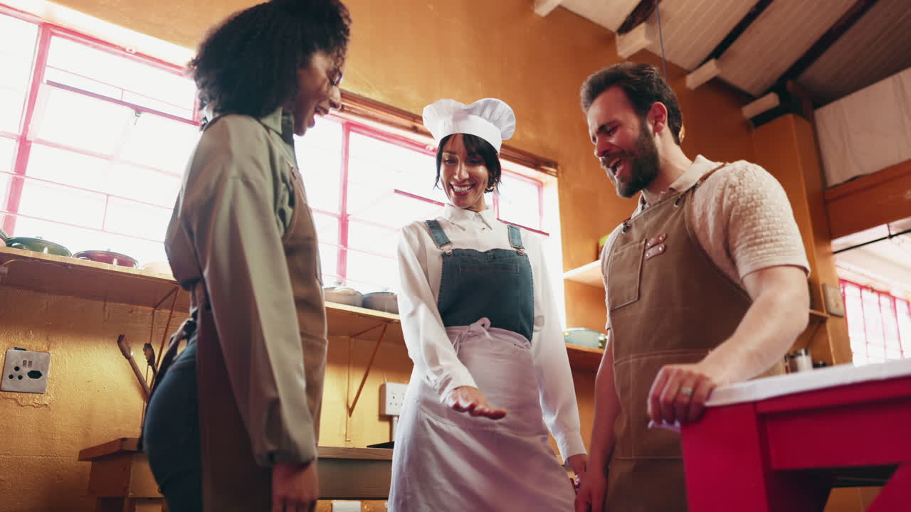 Team of chefs celebrate success in restaurant kitchen