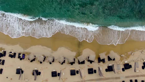 Toma-De-Arriba-Hacia-Abajo-De-Las-Olas-Rompiendo-Sobre-La-Playa-De-Arena-Dorada-Con-Tumbonas-Que-Bordean-El-Borde-Del-Agua