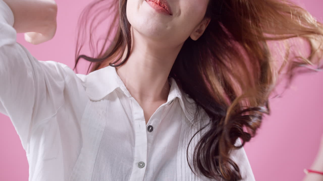 쾌활한 예쁜 소녀가 앉아서 실내에서 카메라를 보고 웃고 있습니다.