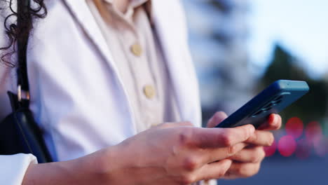 Woman,-phone-and-hands-typing-in-city