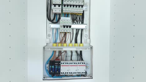close-up of an open electrical panel with various circuit breakers and intricate wiring