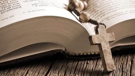 Rosary-beads-placed-on-open-bible-close-up-panning-shot