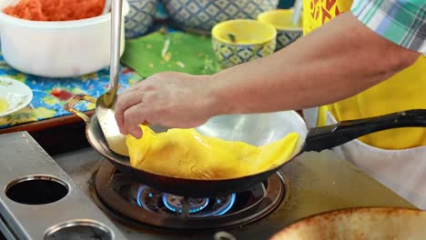 chef prepares pad thai at bangkok's floating market