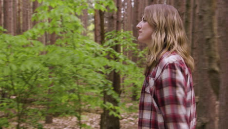 handheld shot of a young woman walking through the woods