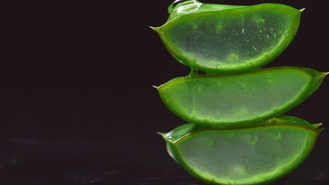 slices of fresh green aloe vera plant stacked pieces of leaves with transparent extract gel flows through the ingredients. natural medical plant for organic cosmetics, alternative medicine. vertical