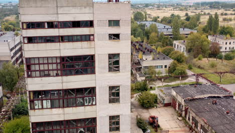 tall building with broken windows and roof. exterior of an old abandoned building on empty manufacturing. damaged house.