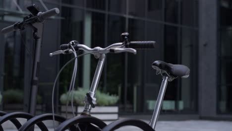 closeup bicycle standing at parking lot with electric scooter. silver handlebar