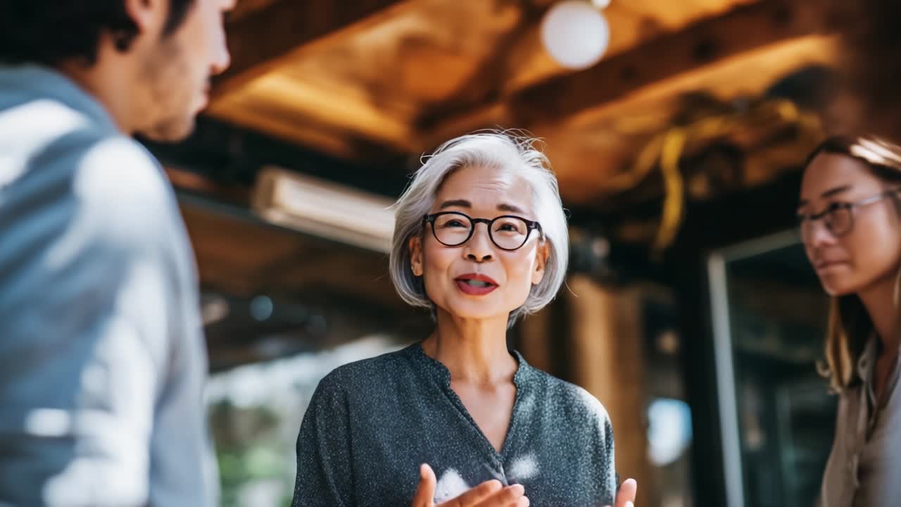 Engaging Conversation with a Senior Woman in a Casual Setting, Highlighting Her Expressive Gestures and Subtle Interactions with Younger Individuals, Delving into Themes of Communication and Connection