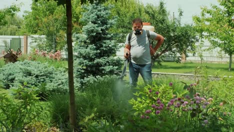 pulverizar pesticidas ecológicos. el agricultor fumiga en máscara protectora y gafas árboles y arbustos.
