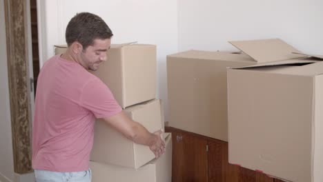 chico joven entrando en una nueva casa o apartamento por primera vez