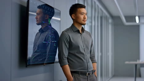 thoughtful asian businessman in a modern office with data display