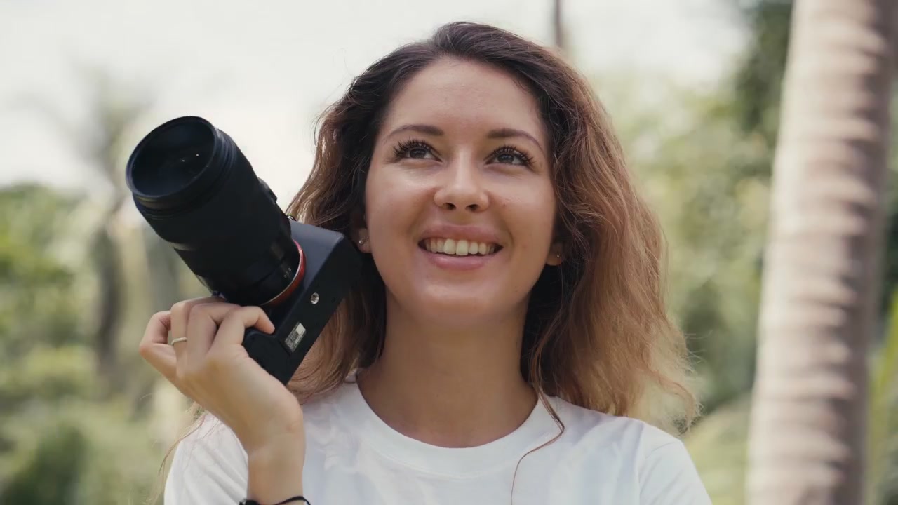 Giovane fotografa con macchina fotografica all'aperto in un ambiente tropicale
