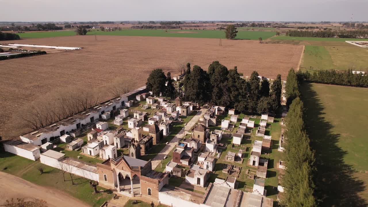 tranquilidad rural en un pequeño cementerio enclavado entre tierras de cultivo - aérea