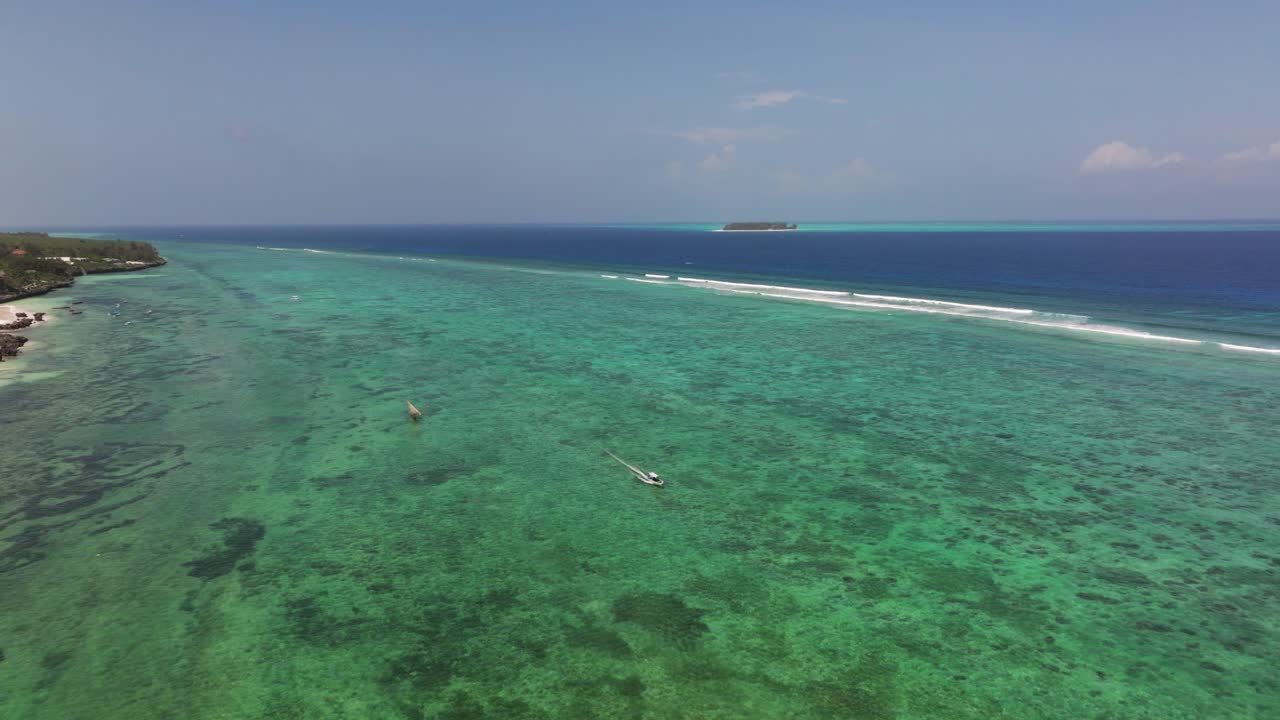 Matemwe beach, Overhead drone view of clear turquoise ocean water with coral formations off Zanzibar coast, establishing above tour boats