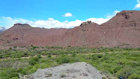 Panning-shot-of-a-spectacular-sunny-scenic-green-valley-and-rough-mountain-wilderness