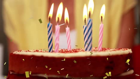 animación de confeti de oro cayendo sobre velas encendidas en el pastel de cumpleaños