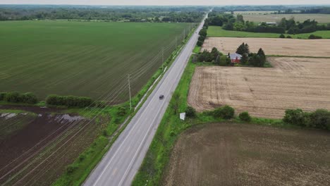 Aerial-View-Of-A-Country-Road-Between-Rural-Fields