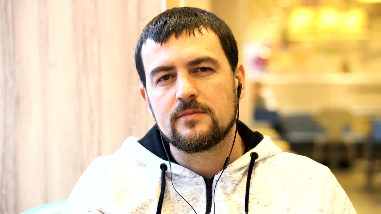 un joven sonriendo a la cámara en el café.