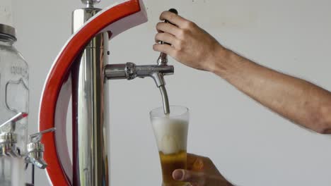 Close-Shot-of-a-White-Male-Pouring-a-Glass-of-Beer-at-the-Beer-Pump