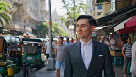 man in a suit walking through a bustling asian street market
