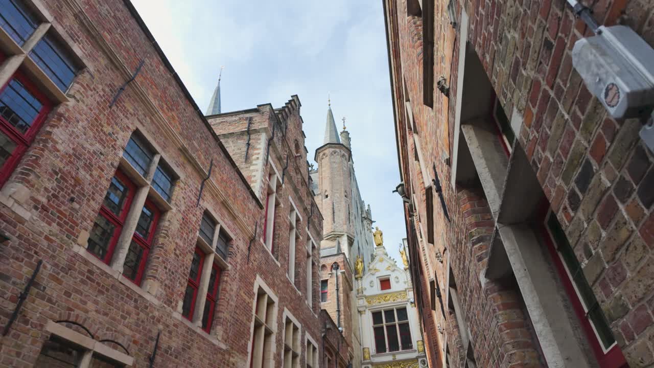 Bruges City Hall with gothic spires, iconic medieval architecture in historic city center, low angle view