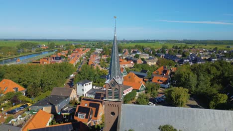 circle pan to right on church bell tower of cute dutch village ilpendam in the netherlands