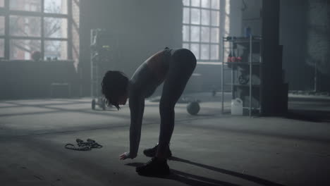 Woman-bending-forward-during-training-in-gym.-Fitness-girl-stretching-body