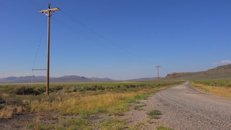 un camino desierto solitario está bordeado de postes telefónicos