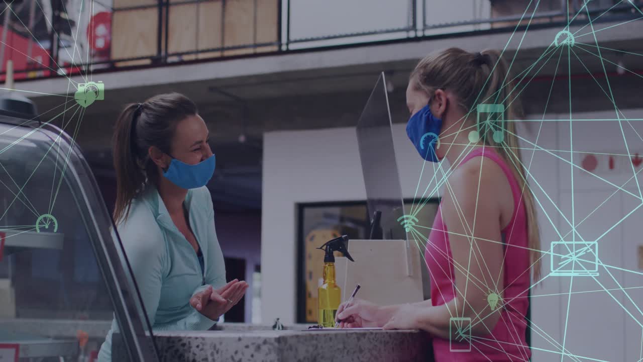 animación de iconos de los medios sobre dos amigas caucásicas con máscaras faciales hablando