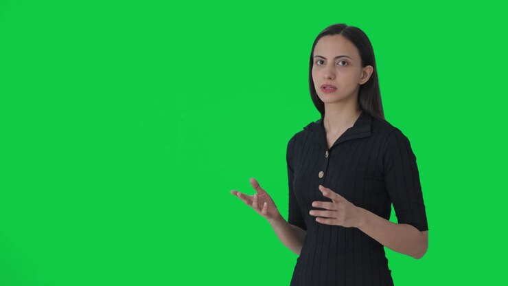 periodista india que apunta a una pantalla verde en blanco