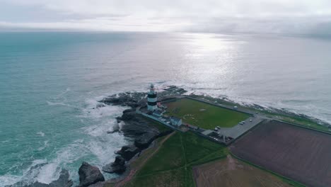 Lighthouse-along-a-cliff-by-the-ocean-aerial