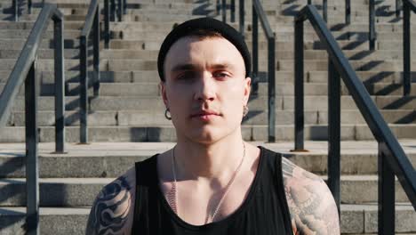 portrait of contemporary hip hop street dancer hipster man with tattoo looking into camera