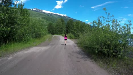 Vista-Trasera-De-Una-Mujer-En-Forma-Corriendo-Por-La-Carretera-4k