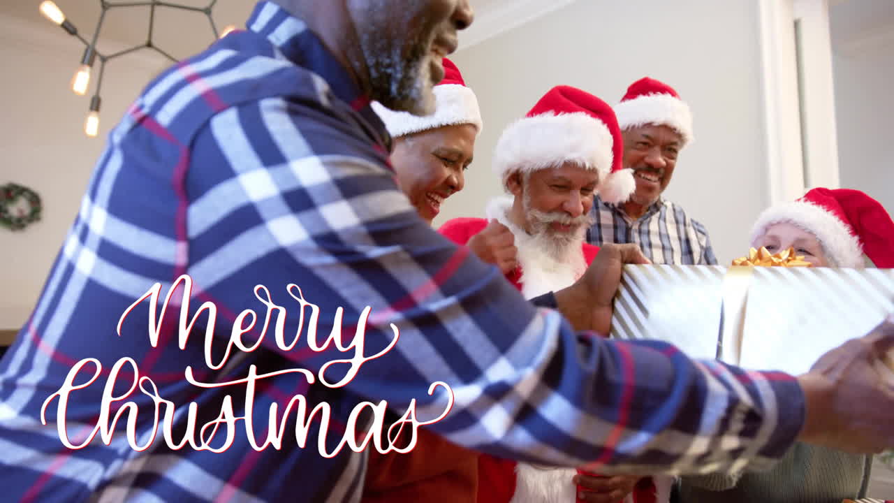 animación de texto de feliz navidad sobre diversos amigos mayores con regalos de navidad en casa