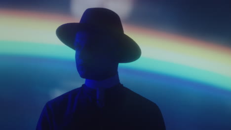 man in priest robe and hat posing in neon light