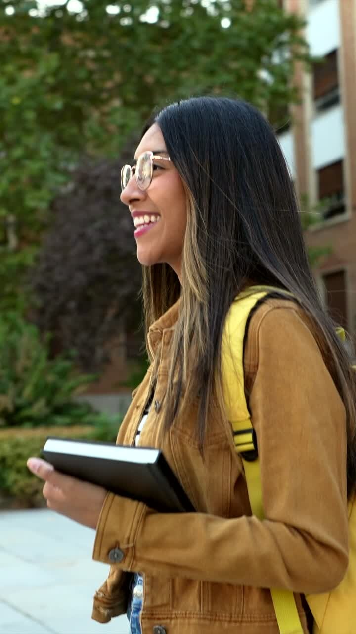 Young woman on campus with backpack and notebook
