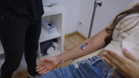 medical professional performing a blood draw or iv insertion on a patient