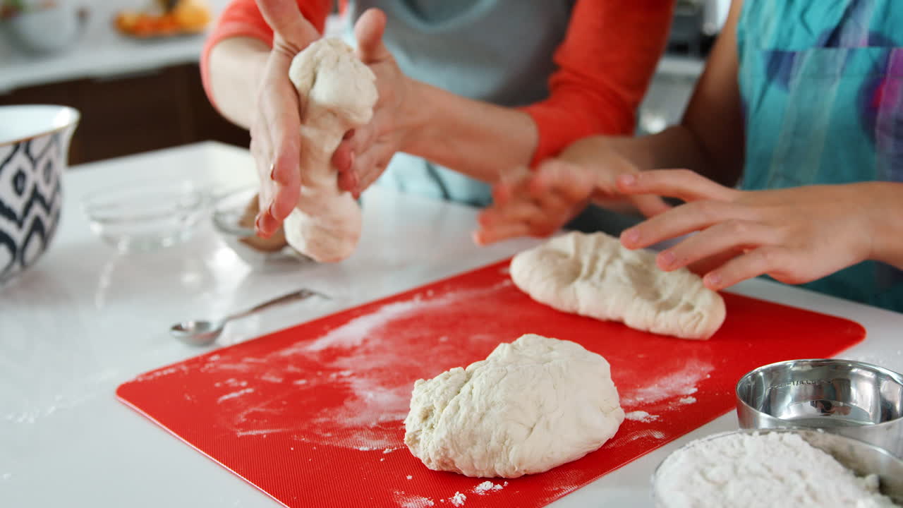 Women preparing dough for challah bread, close up of hands