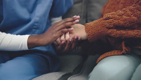 Nurse,-woman-and-holding-hands-on-sofa