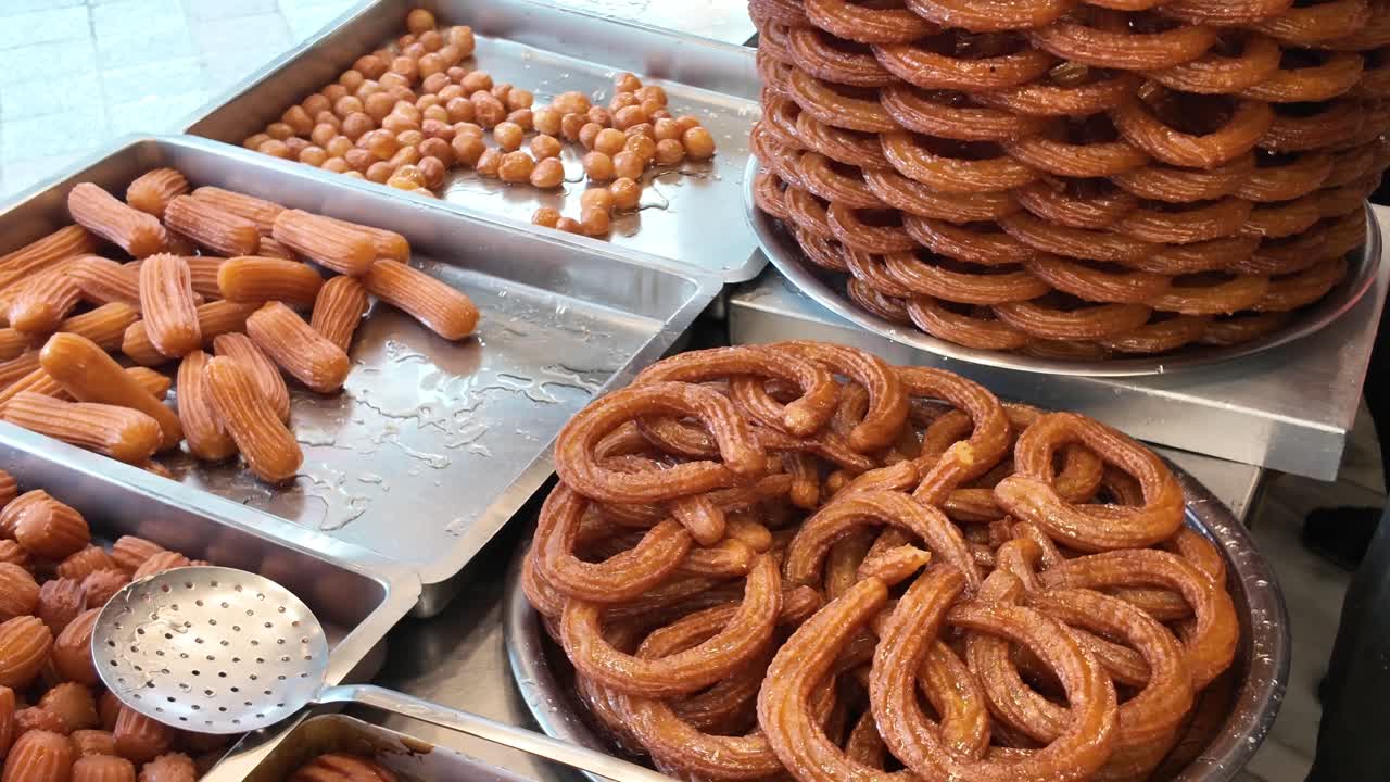 Variety of Traditional Syrupy Fried Dough Desserts at a Market