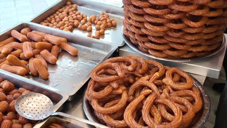 variety of traditional syrupy fried dough desserts at a market