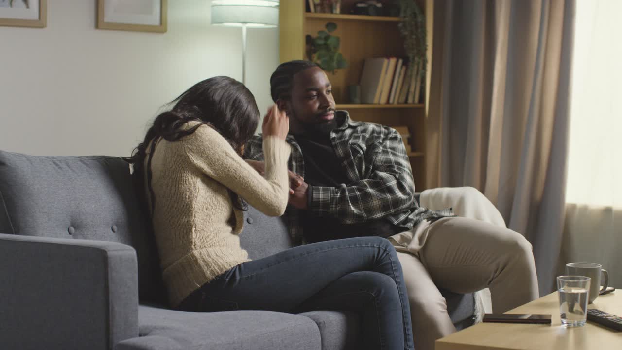 Young Couple Relaxing At Home Sitting On Sofa Talking Together 6