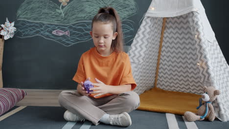 girl playing with play-doh in a play tent