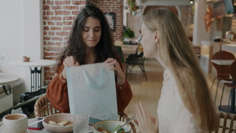 friends unboxing a gift in a cafe